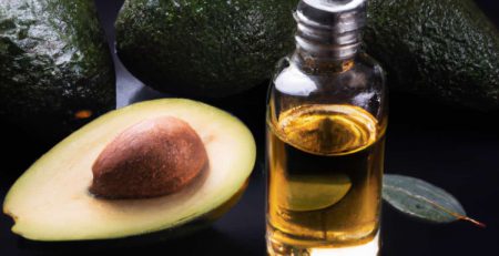 Cold pressed avocado oil in a bottle. Surrounded by fresh organic avocados